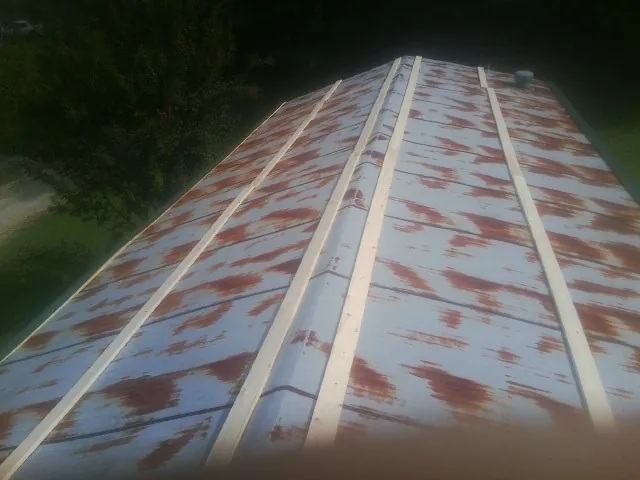 Rusted metal roof panels with new wood purlins before replacement — Storm Damage Roof Repair in Godwin by Roofing Brothers