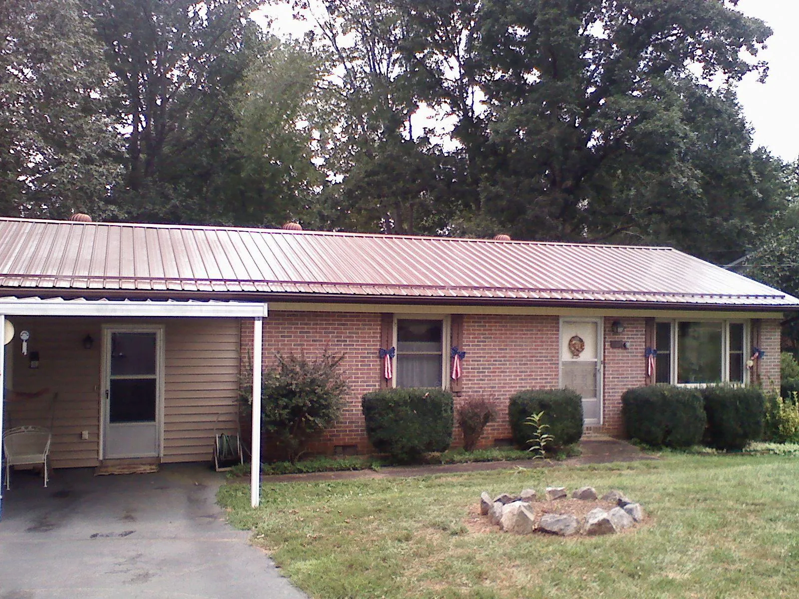Bronze metal roof and carport on a brick ranch home — Roof Repair work by our crew in Godwin
